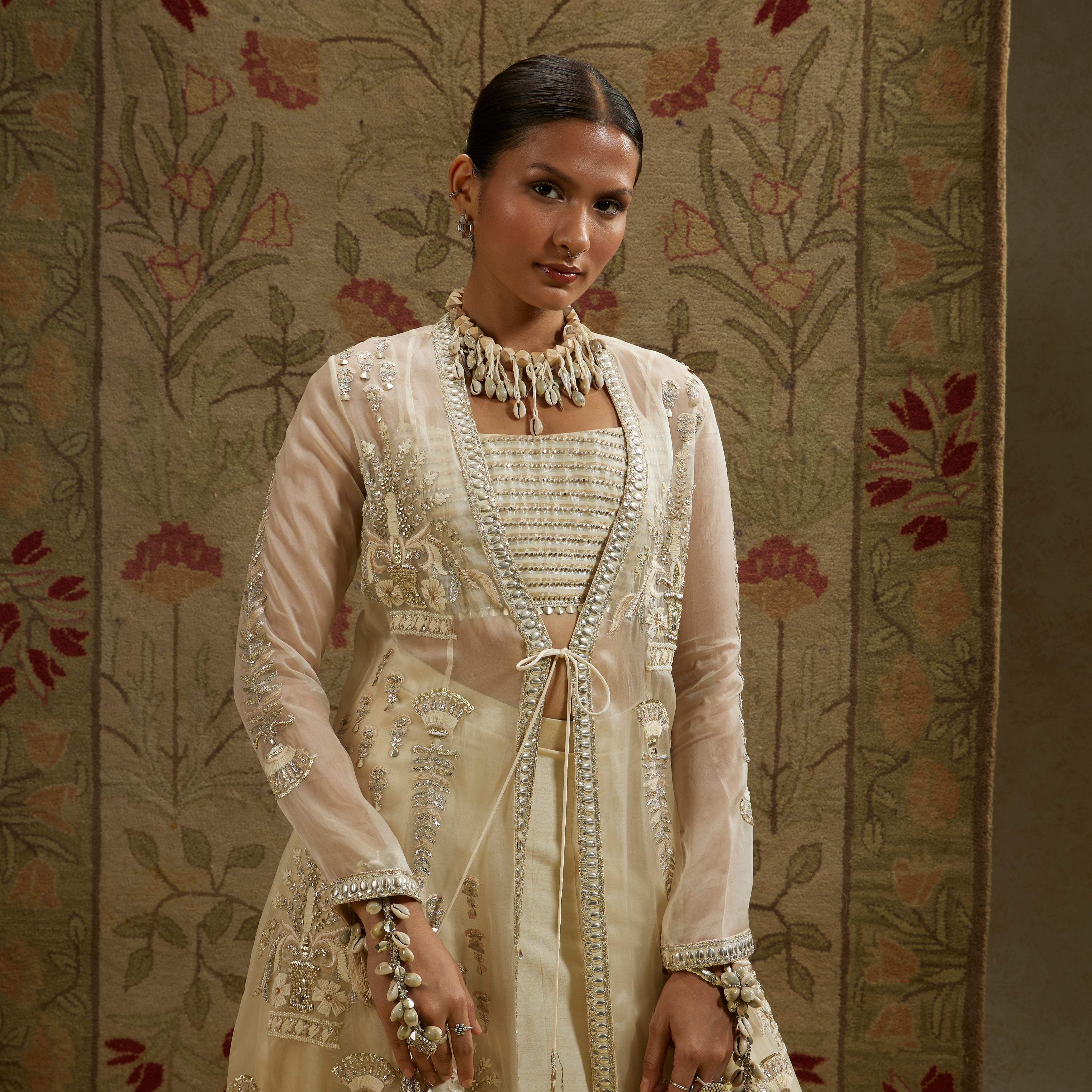 MEHEK: MAGNOLIA ORGANZA EMBELLISHED JACKET PAIRED WITH METAL BUSTIER AND LEHENGA