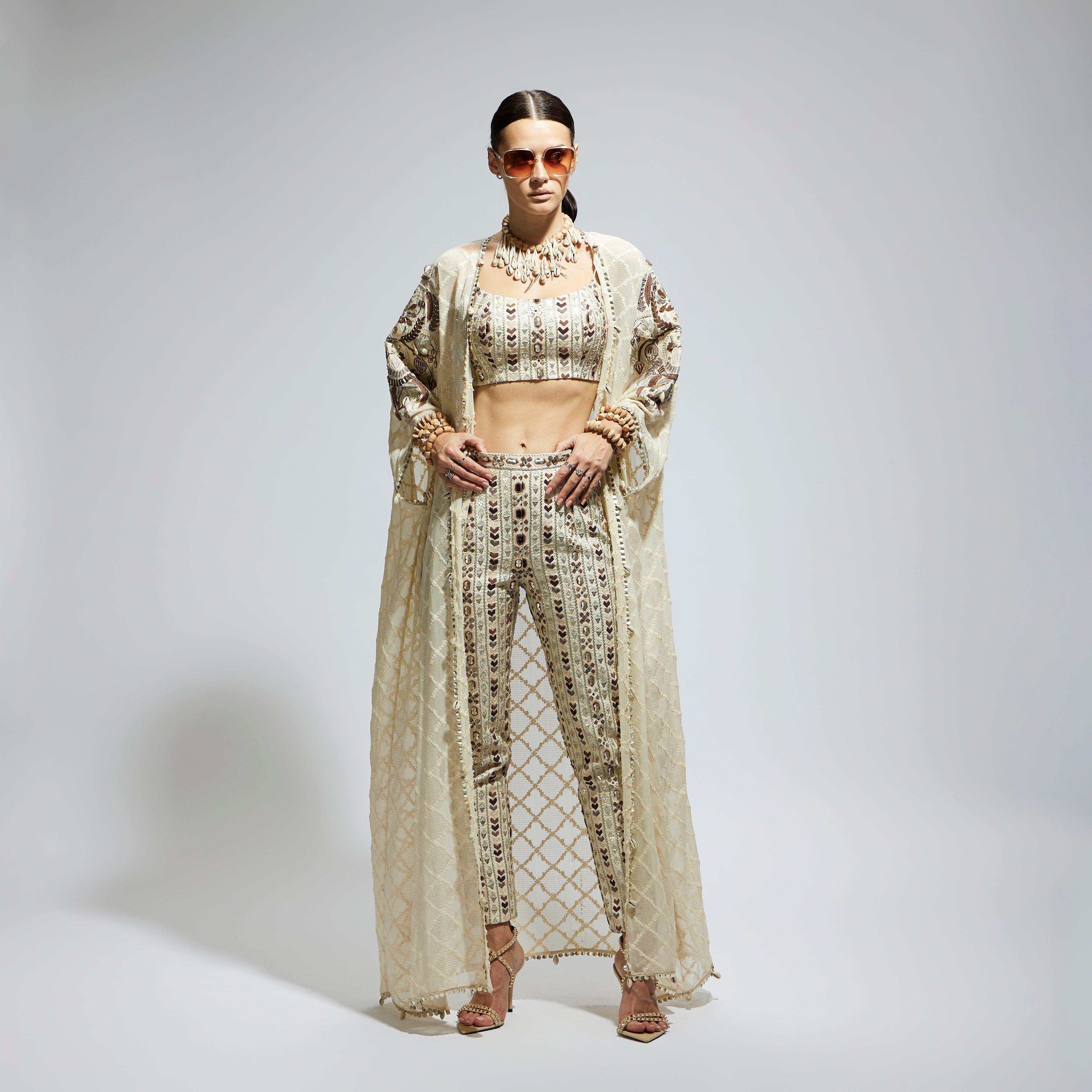 IVORY AZTEC EMBELLISHED CAPE PAIRED WITH HEAVILY EMBELLISHED BUSTIER AND PANTS