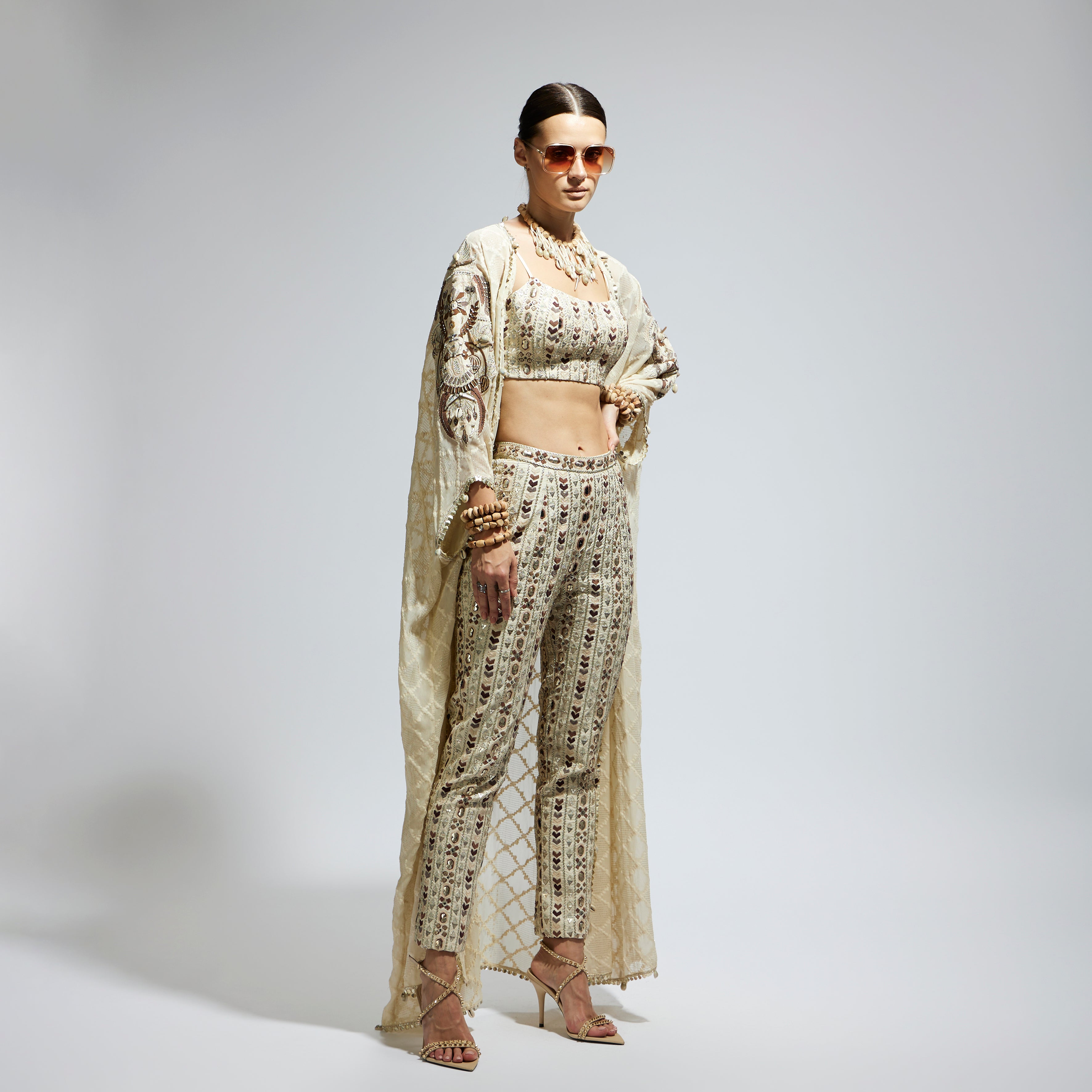 IVORY AZTEC EMBELLISHED CAPE PAIRED WITH HEAVILY EMBELLISHED BUSTIER AND PANTS