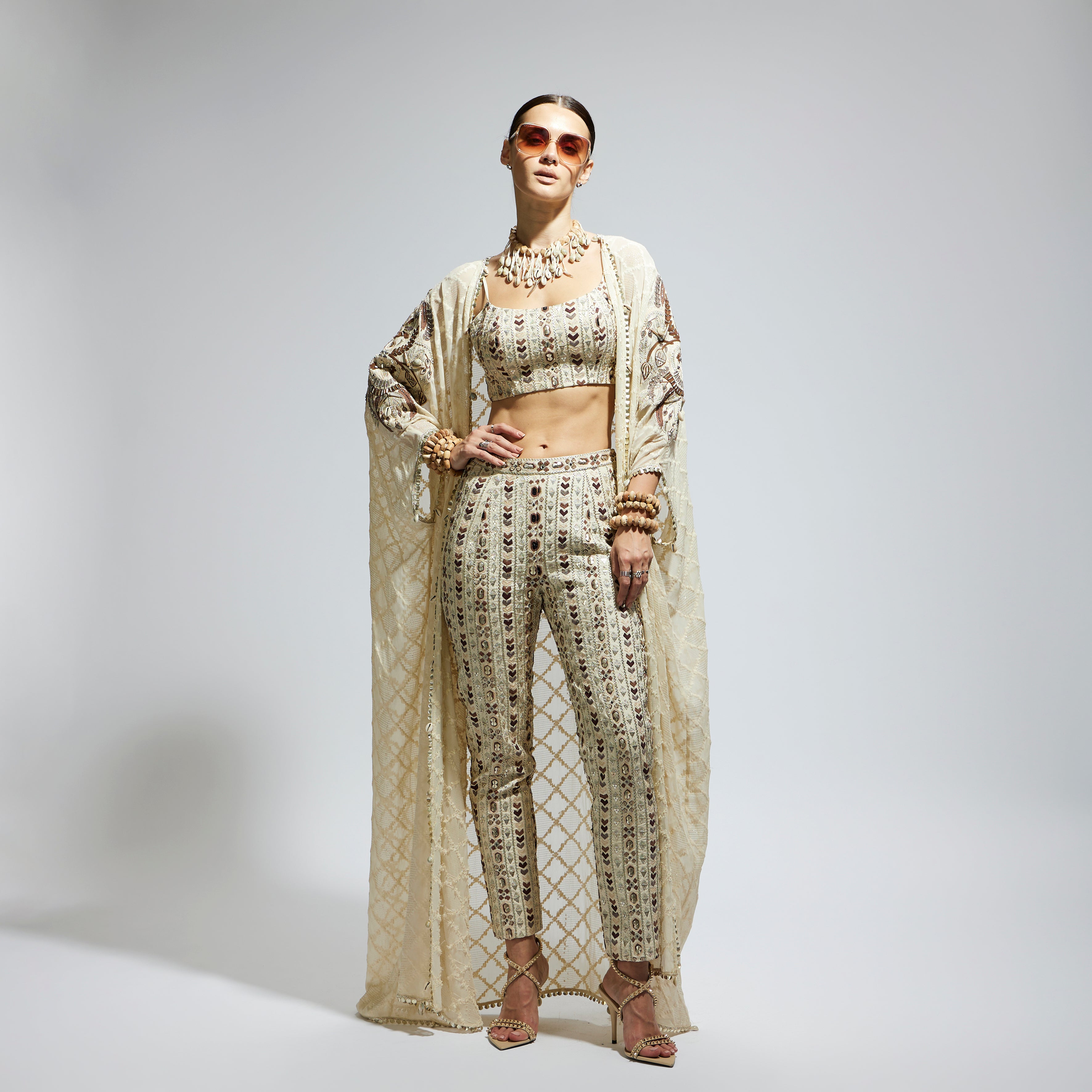 IVORY AZTEC EMBELLISHED CAPE PAIRED WITH HEAVILY EMBELLISHED BUSTIER AND PANTS