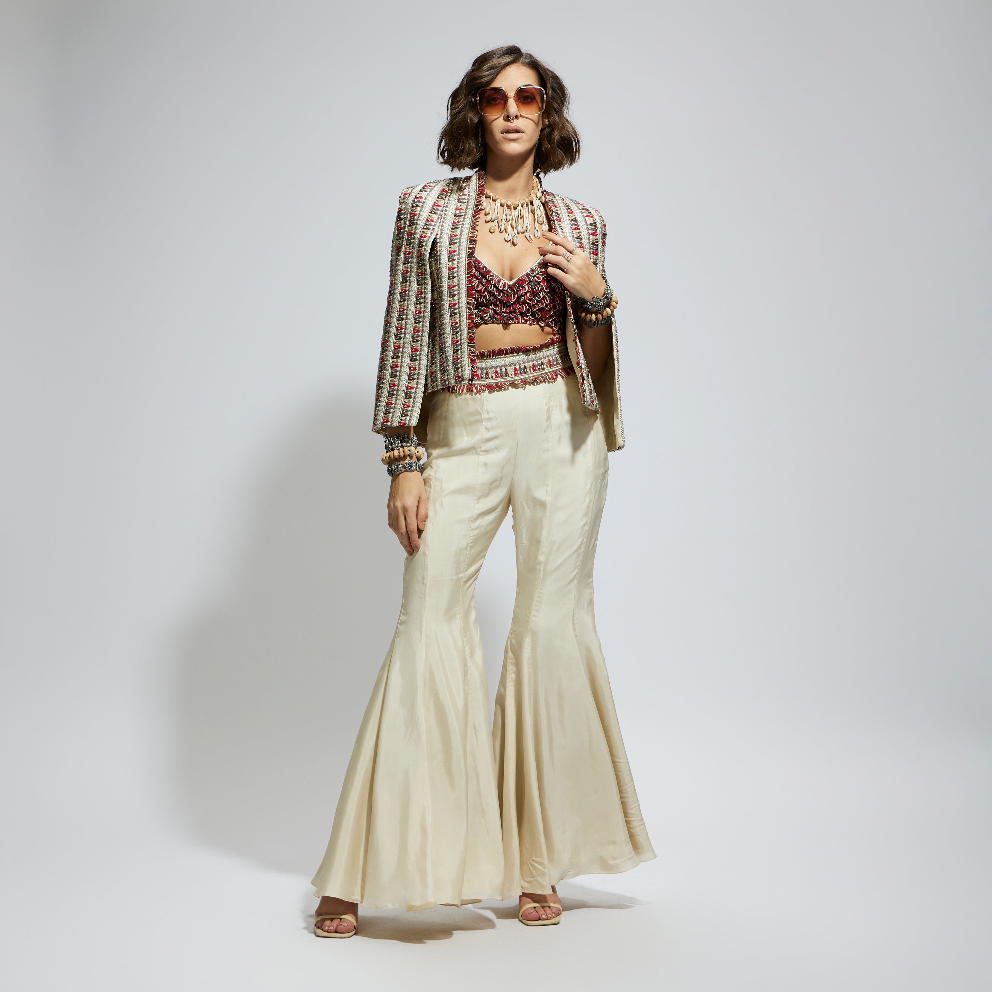 IVORY EMBELLISHED CAPE JACKET PAIRED WITH TEXTURED BUSTIER AND SHARARA PANTS