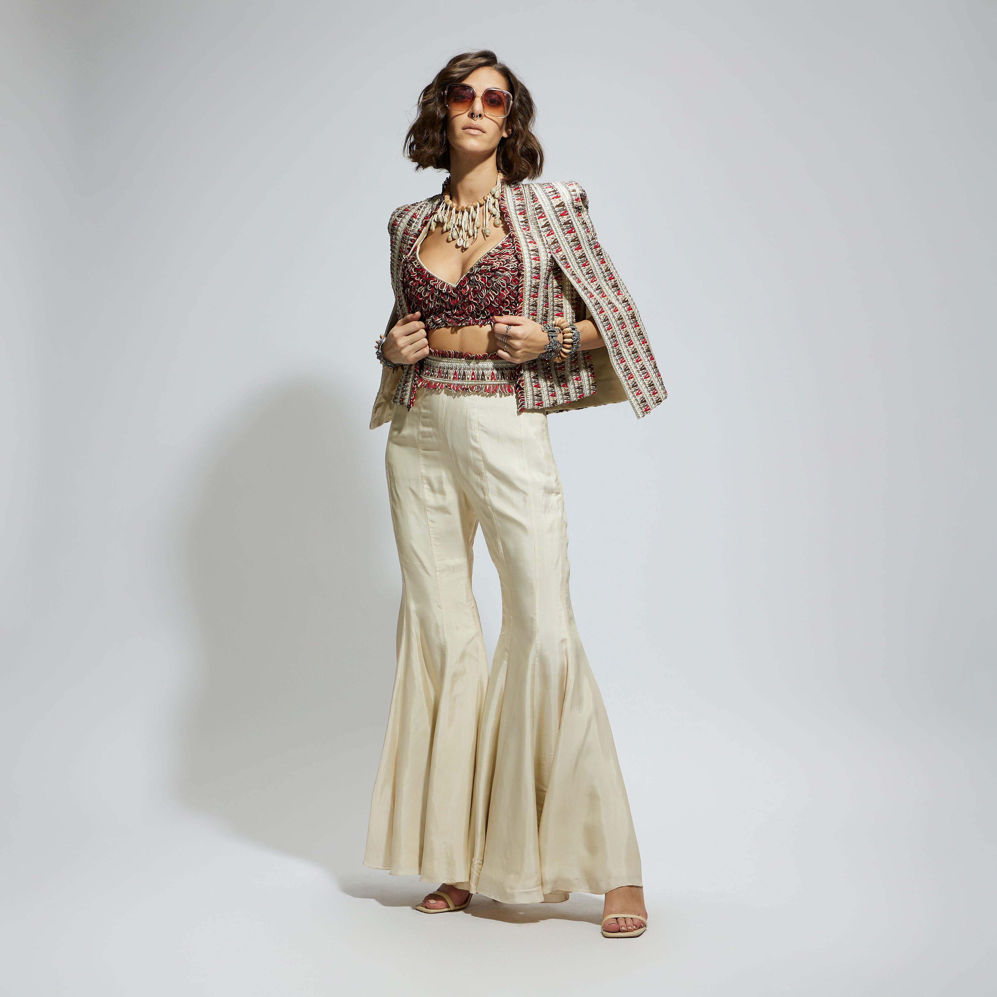 IVORY EMBELLISHED CAPE JACKET PAIRED WITH TEXTURED BUSTIER AND SHARARA PANTS