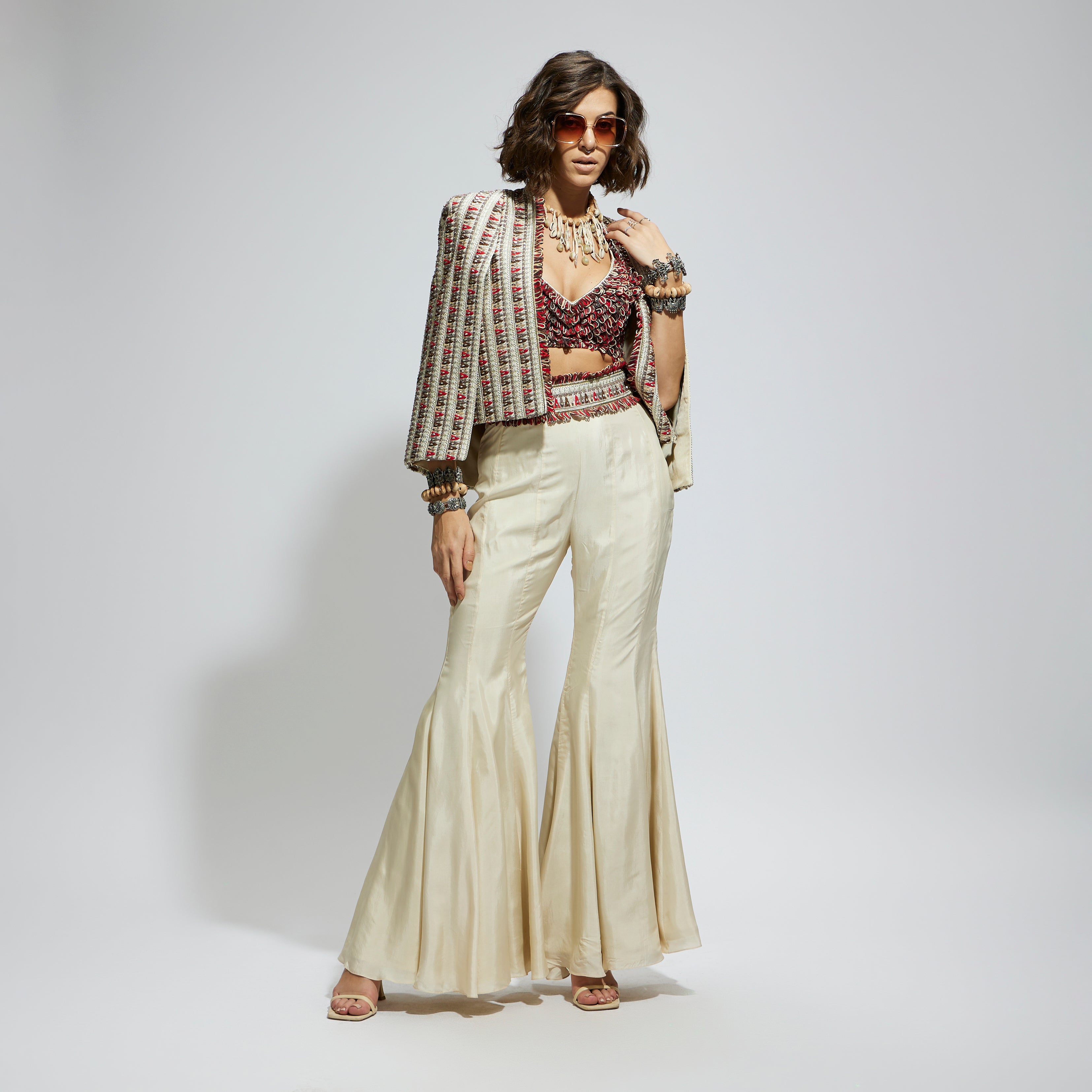 IVORY EMBELLISHED CAPE JACKET PAIRED WITH TEXTURED BUSTIER AND SHARARA PANTS