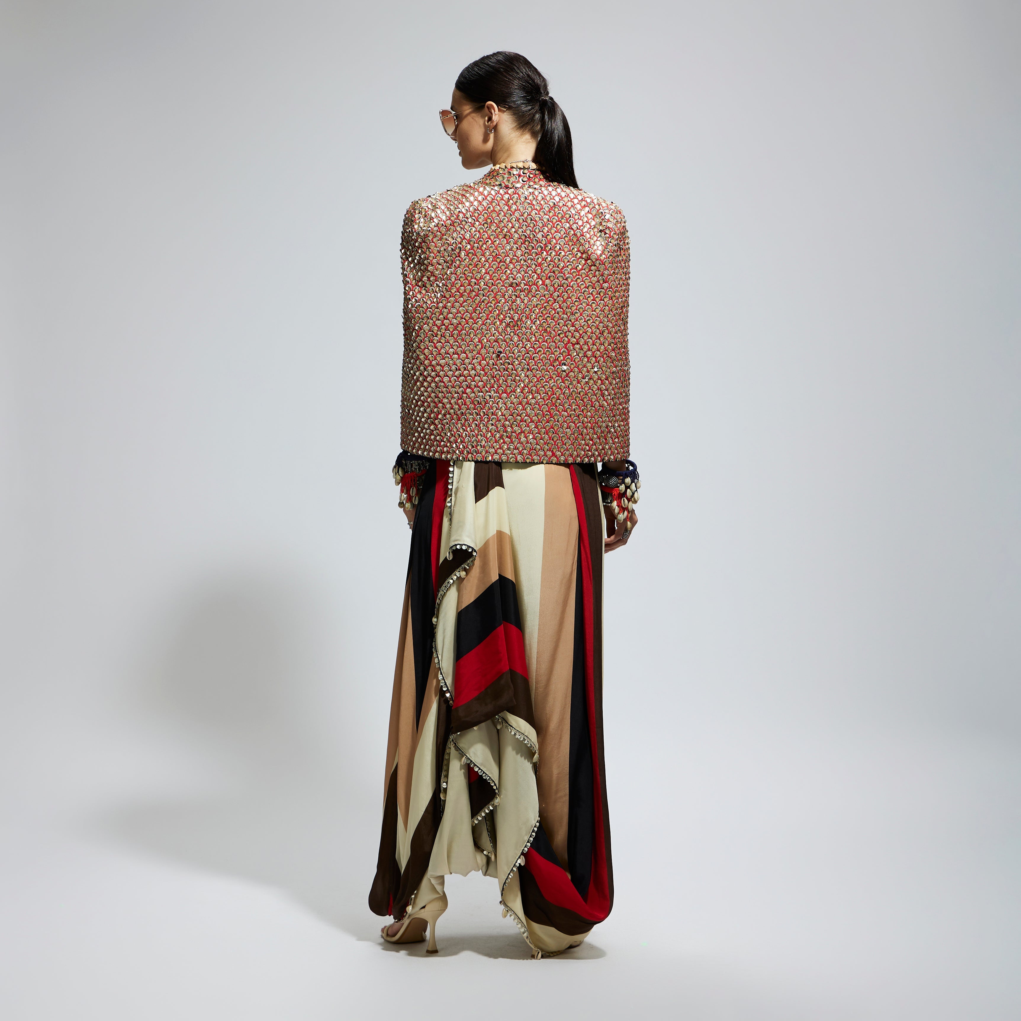 METALLIC EMBELLISHED CAPE JACKET PAIRED WITH STRIPE BUSTIER AND STRIPE DRAPE SKIRT