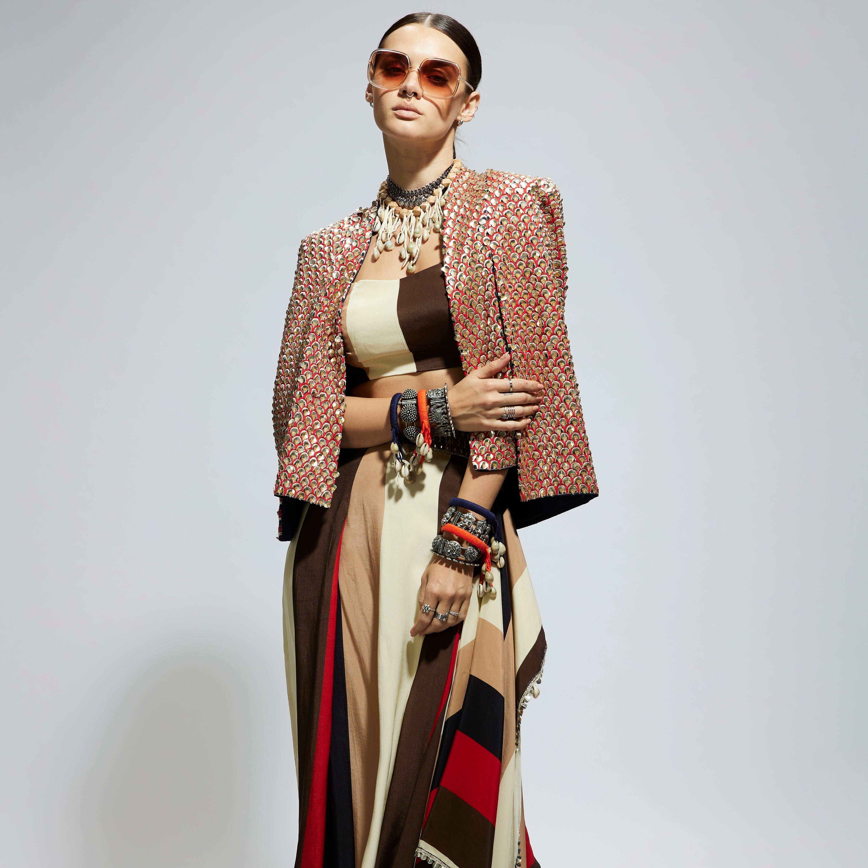 METALLIC EMBELLISHED CAPE JACKET PAIRED WITH STRIPE BUSTIER AND STRIPE DRAPE SKIRT