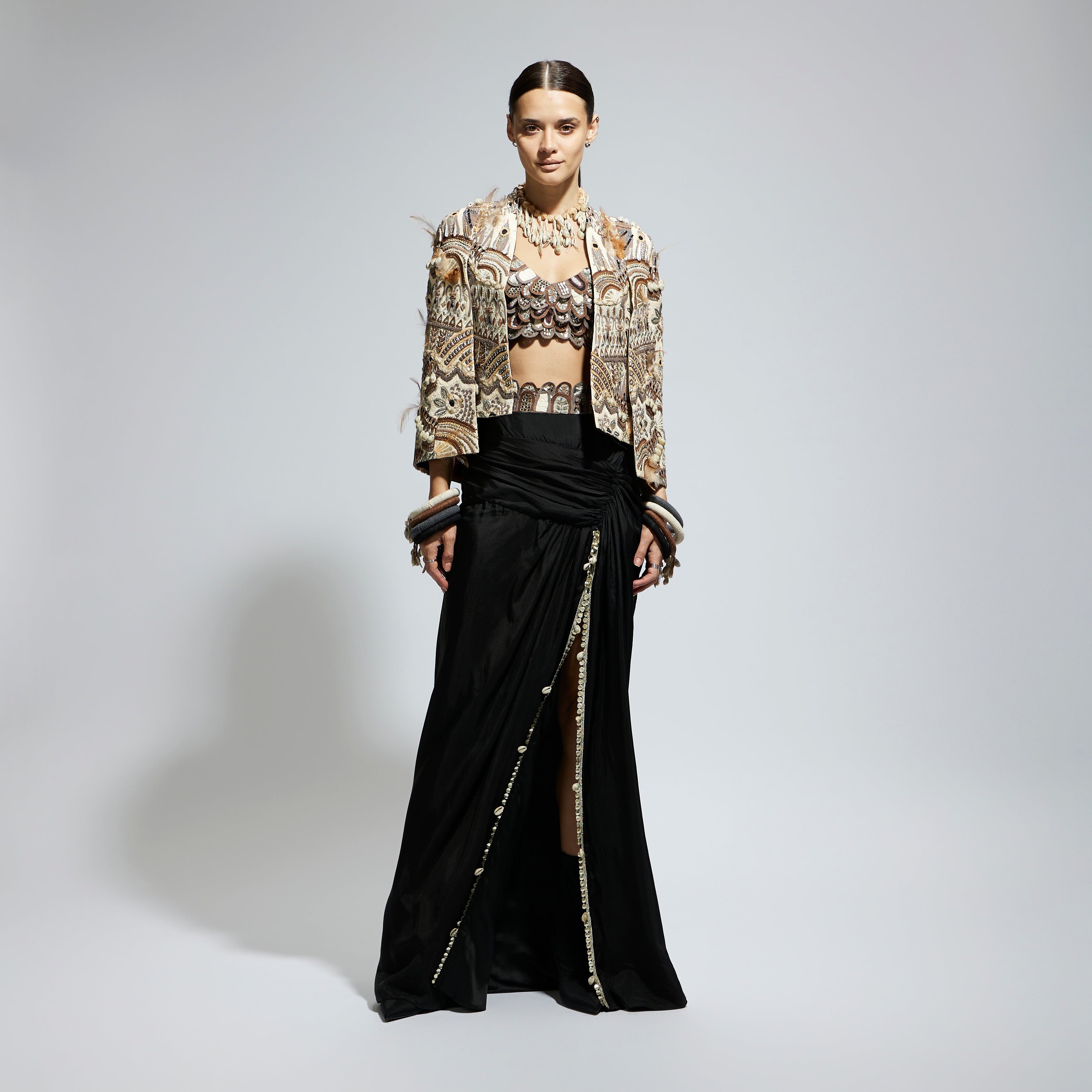 IVORY ABSTRACT FEATHER CAPE JACKET PAIRED WITH 3D SCALLOP BUSTIER AND BLACK HIGH SLIT SKIRT