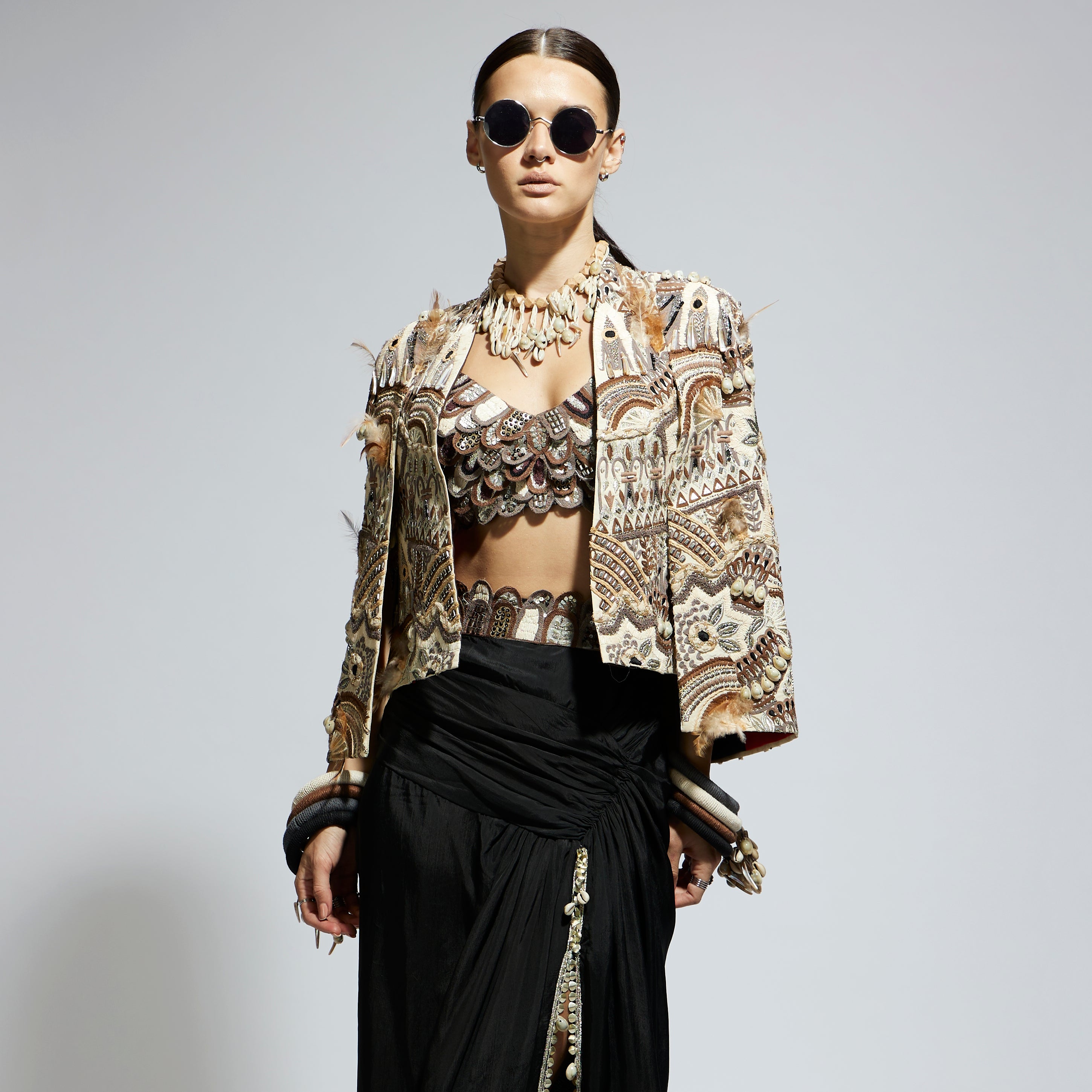 IVORY ABSTRACT FEATHER CAPE JACKET PAIRED WITH 3D SCALLOP BUSTIER AND BLACK HIGH SLIT SKIRT