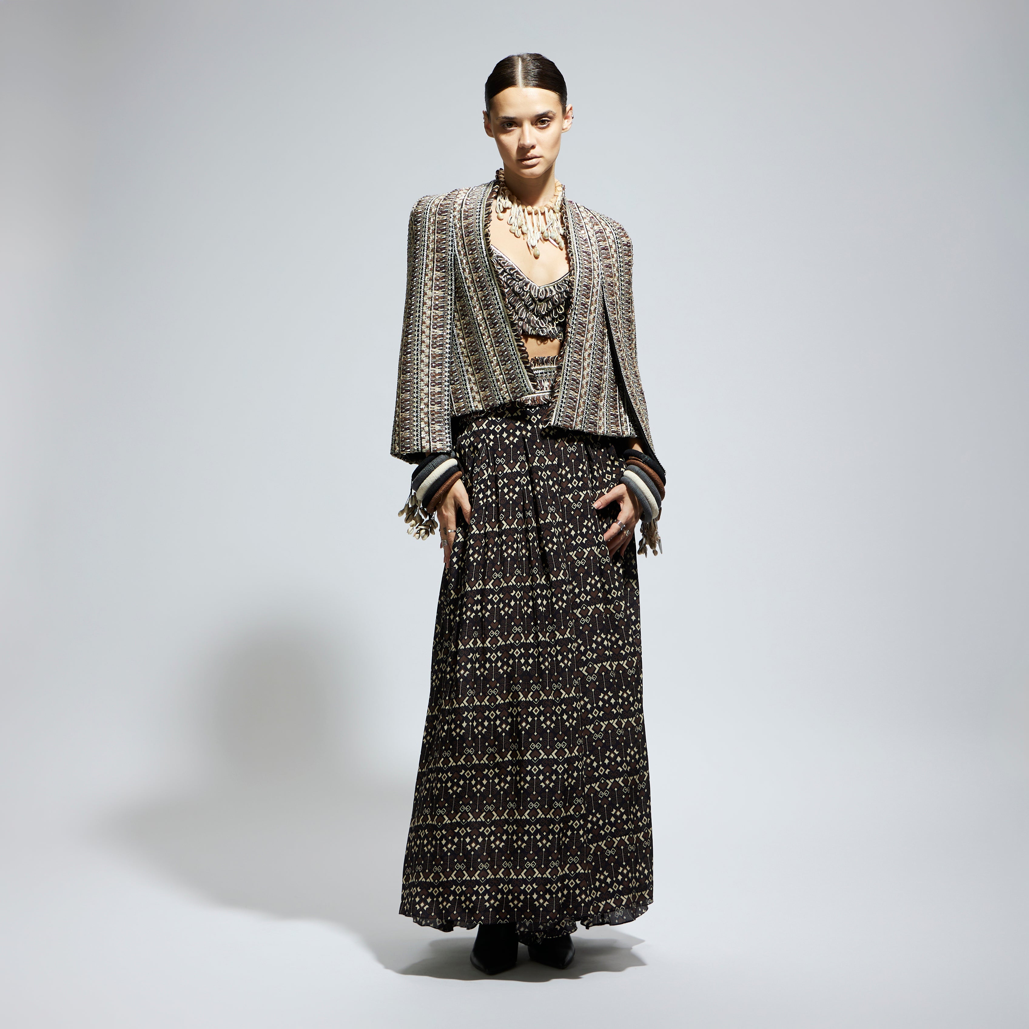 BROWN THREADWORK CAPE JACKET PAIRED WITH TEXTURED BUSTIER AND FLARED PANTS