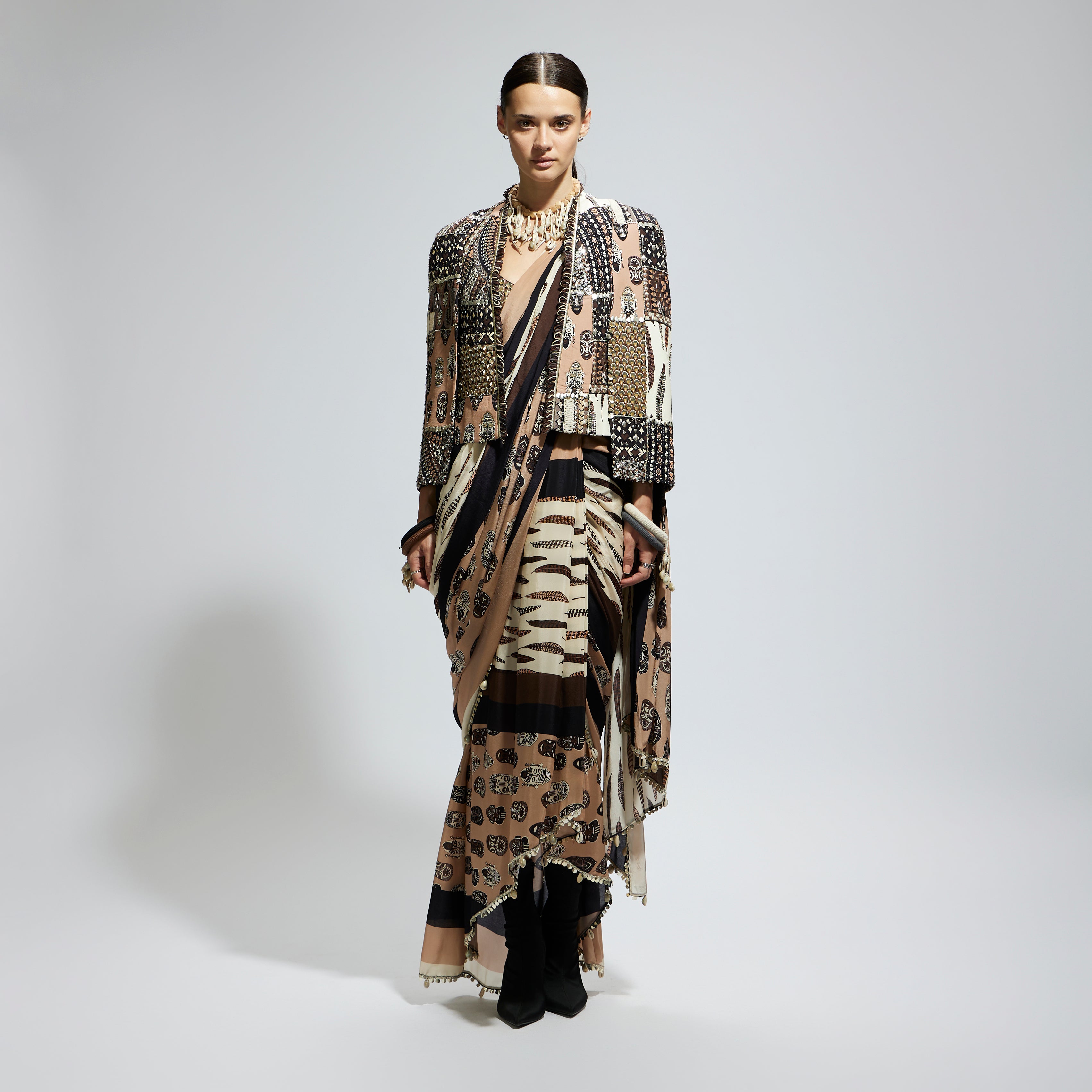 MASK AND FEATHER PRINT CASCADE SAREE PAIRED WITH METALLIC SCALLOP BUSTIER WITH PATCHWORK CAPE JACKET