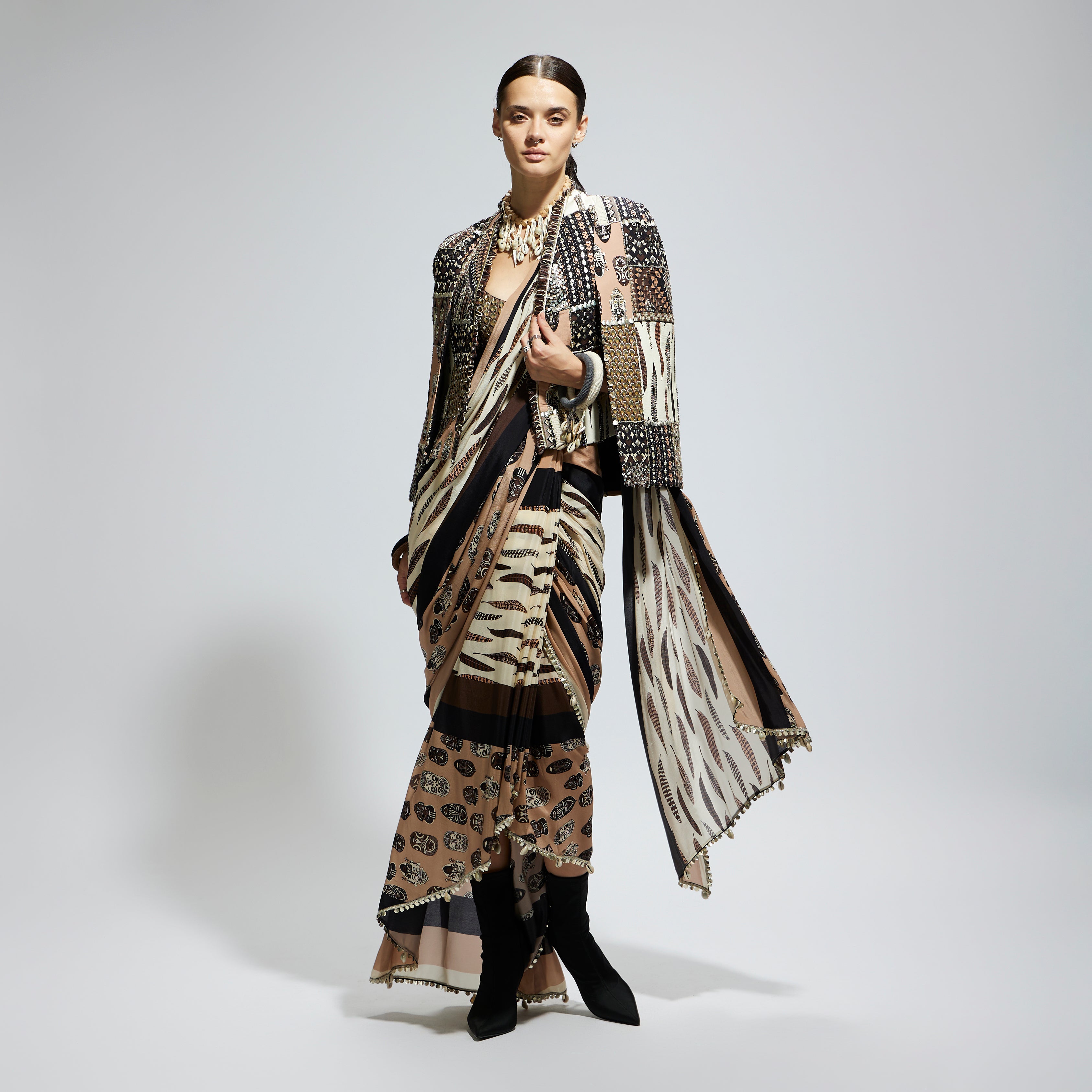 MASK AND FEATHER PRINT CASCADE SAREE PAIRED WITH METALLIC SCALLOP BUSTIER WITH PATCHWORK CAPE JACKET