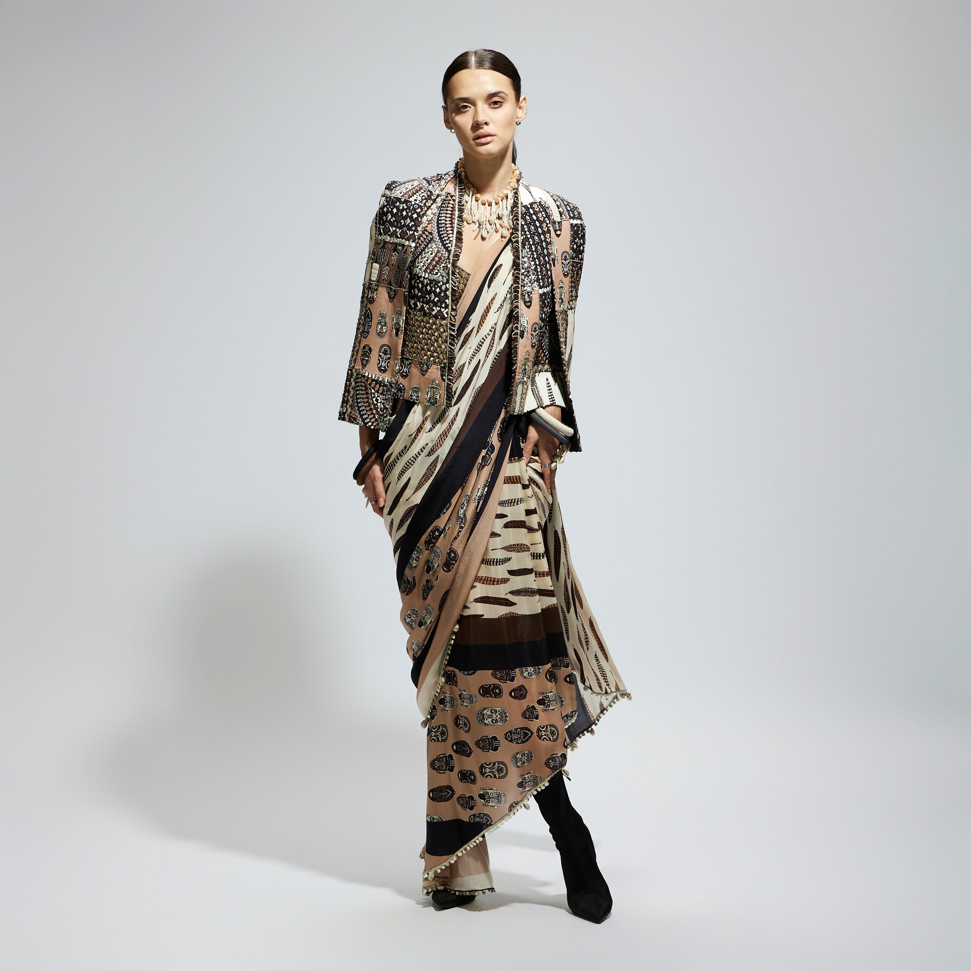 MASK AND FEATHER PRINT CASCADE SAREE PAIRED WITH METALLIC SCALLOP BUSTIER WITH PATCHWORK CAPE JACKET