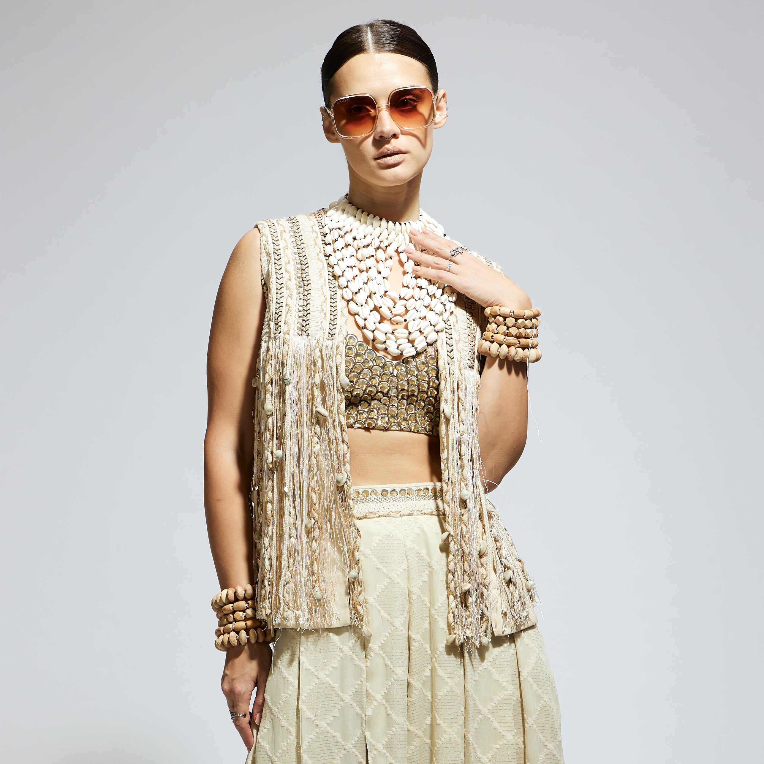 IVORY THREADWORK FRINGE JACKET PAIRED WTH SCALLOP METALLIC BUSTIER AND IVORY AZTEC FLARED PANTS